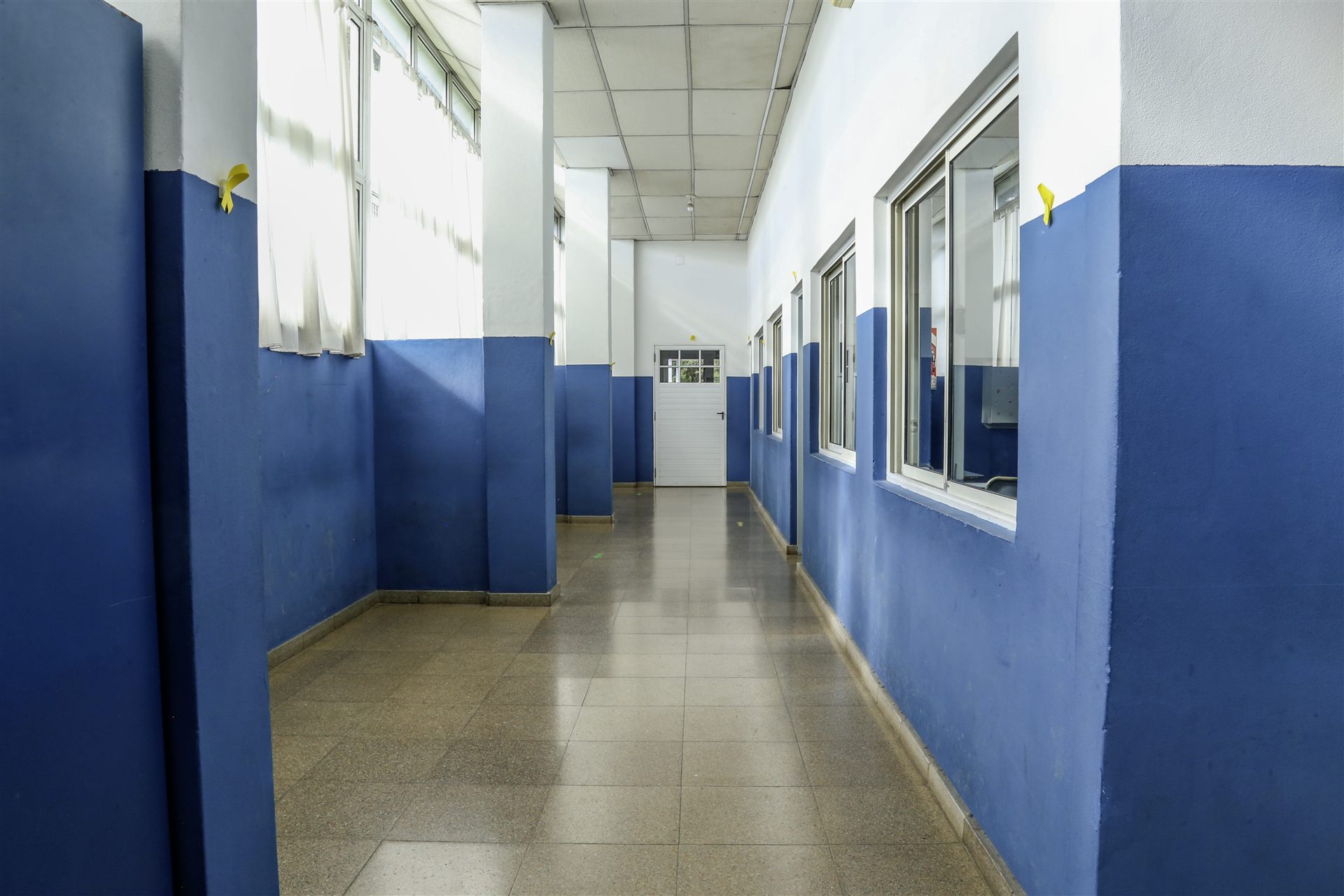 Pasillo con paredes azules y ventanales