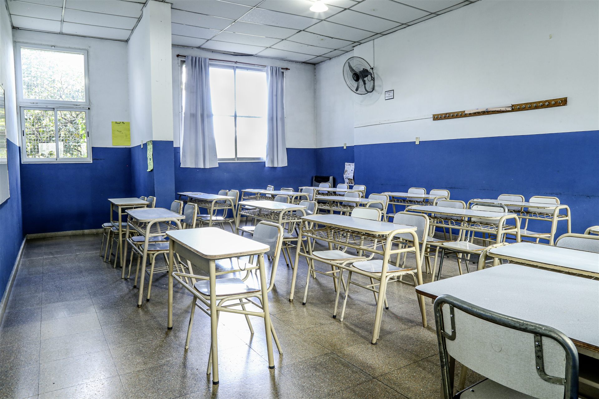 Aula con pupitres, ventanales y cortinas
