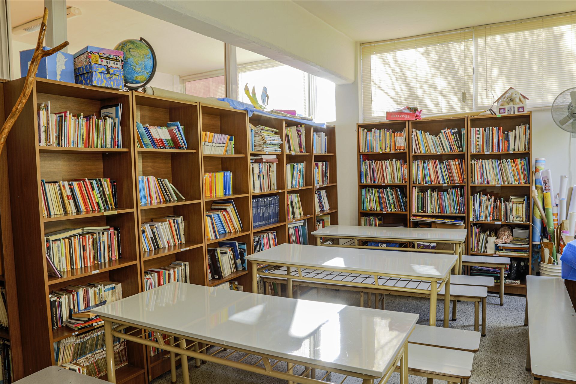 Biblioteca con estanterías llenas de libros y mesas de lectura