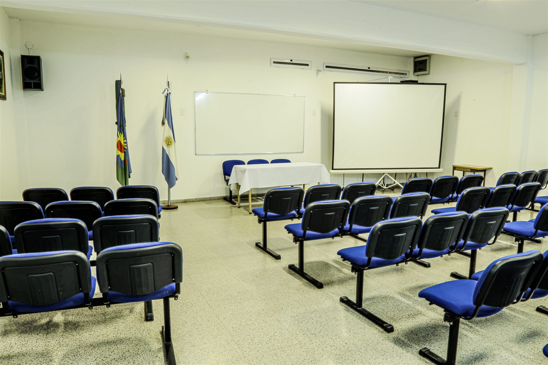 Sala de conferencias con banderas y proyector
